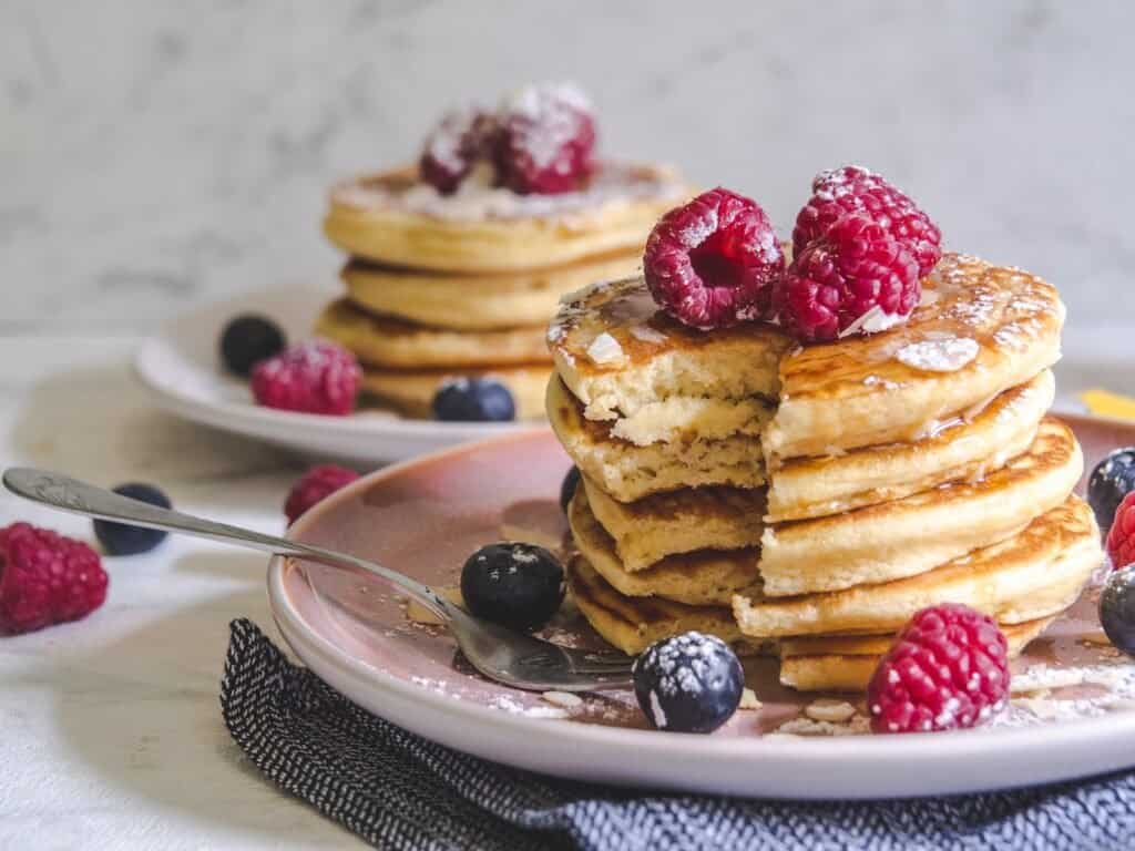 Descubre los Mejores Desayunos en Los Cristianos en Azul Flojito 4 tortitas pancakes flojitos - desayunos en los cristianos - azul flojito -pancakes with berries on white ceramic plate