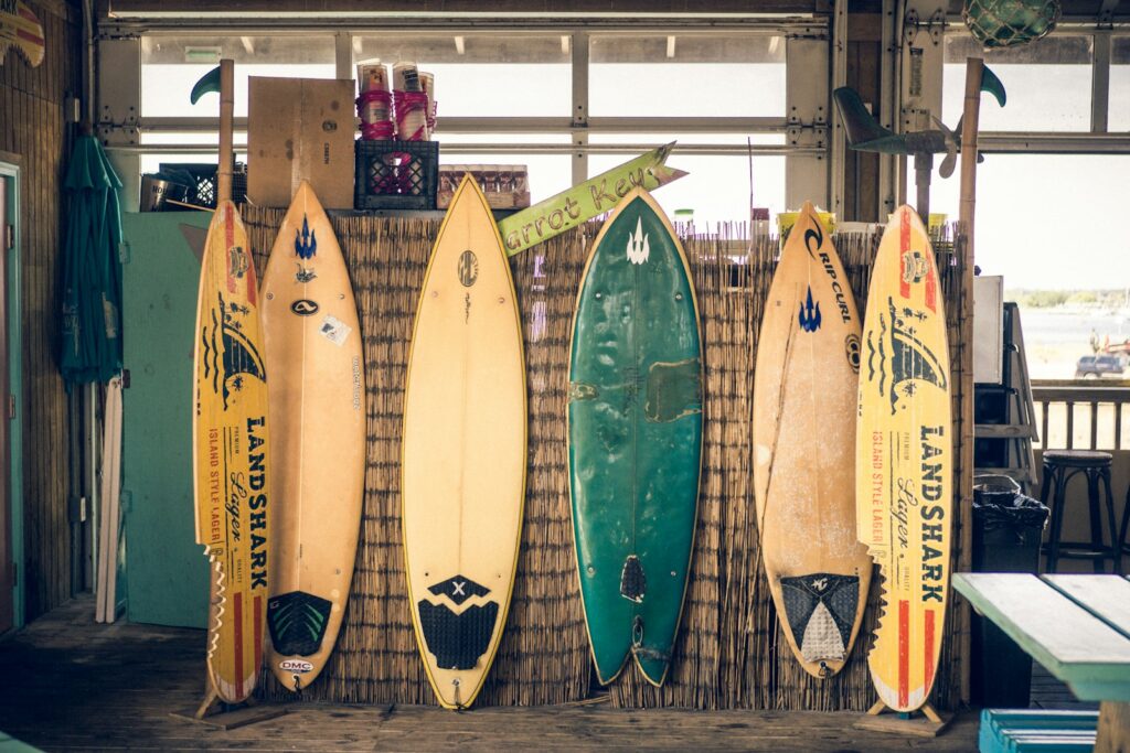 Alquiler de Equipos de Surf en Los Cristianos | Ola Perfecta 3 alquiler de equipos de surf en los cristianos - six assorted-color surfboards on brown board