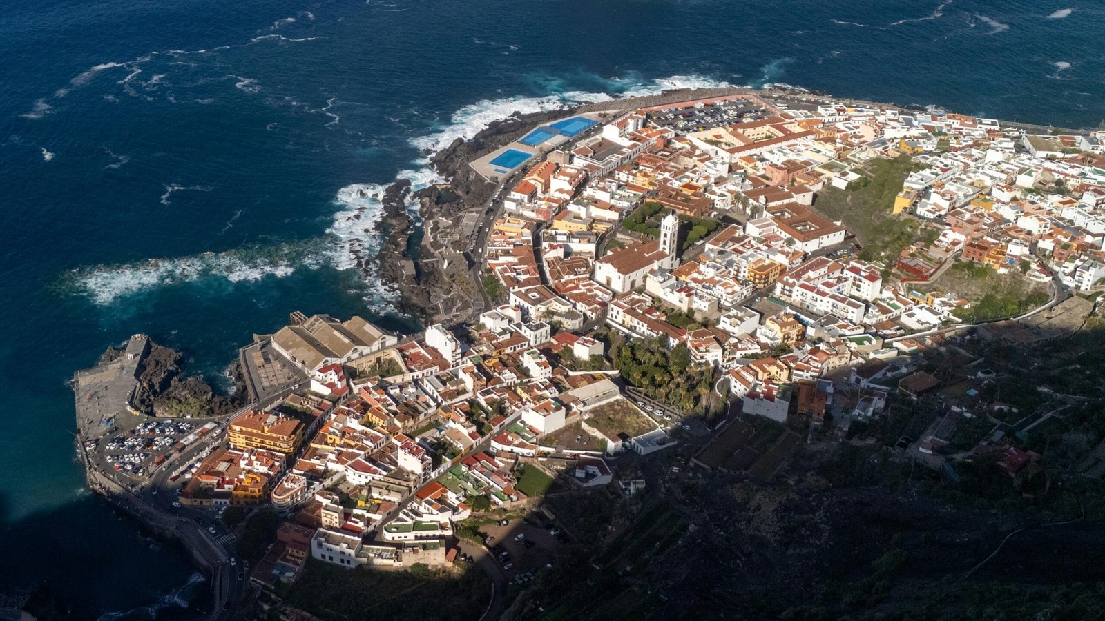 High-angle view of picturesque Garachico, Spain, with coastal landscape and townscape.